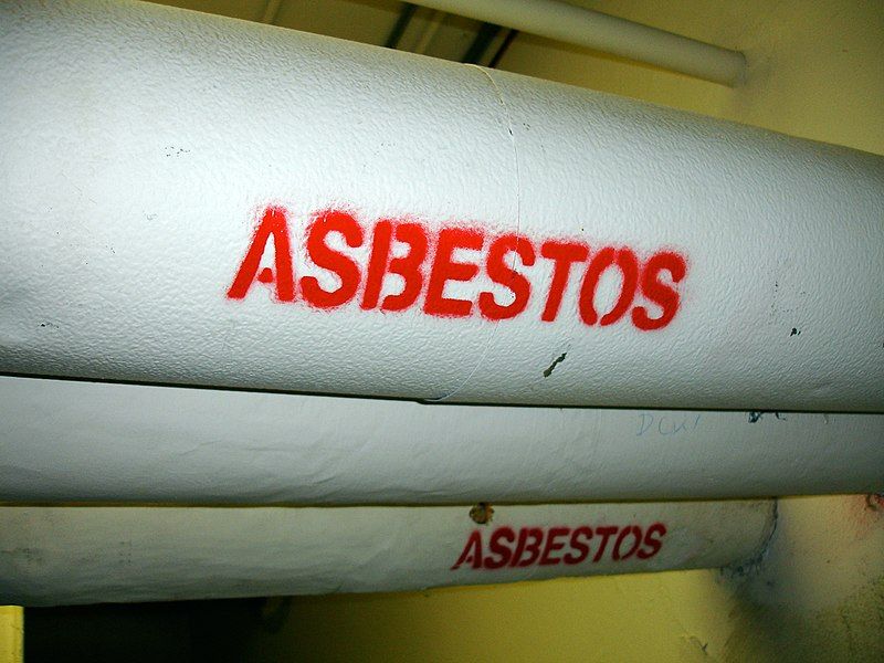 Asbestos written in red on a pipe | featured image for the What to do if You Find Asbestos blog from Asbestos Removals Brisbane.